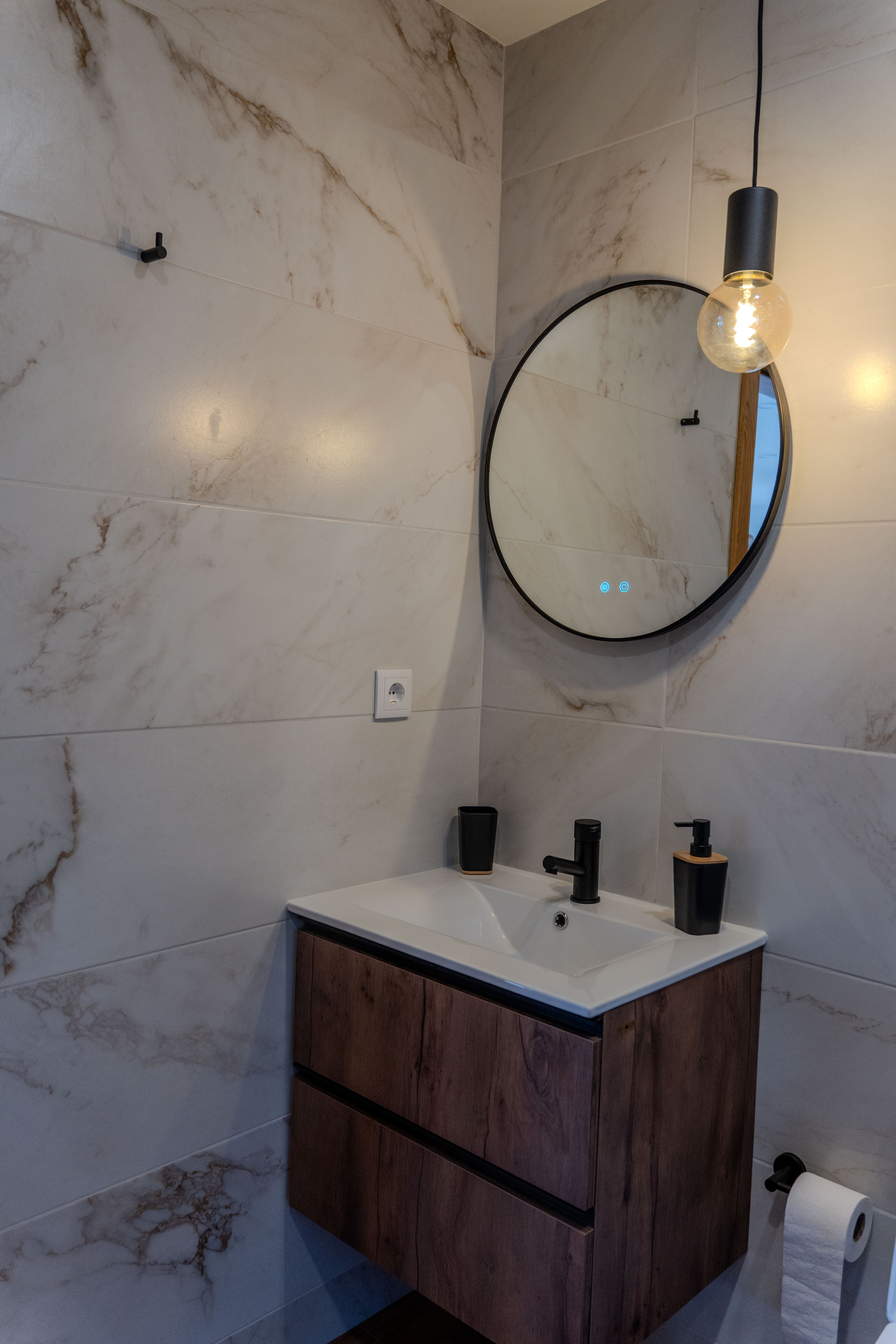 Casa de banho — espelho redondo e iluminação vintage